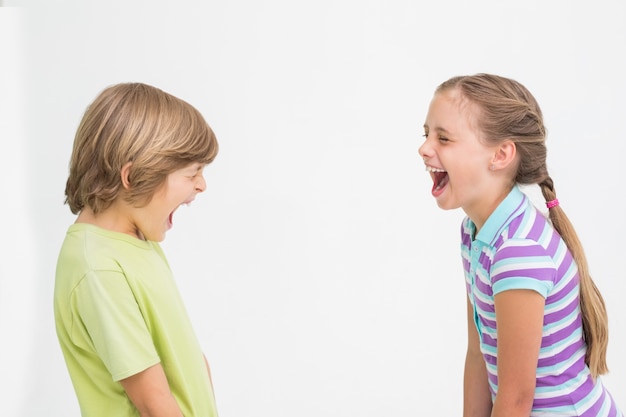 Foto geschwister, die auf weißem hintergrund lachen