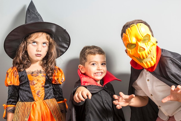 Foto geschwister im halloween-kostüm stehen an der wand