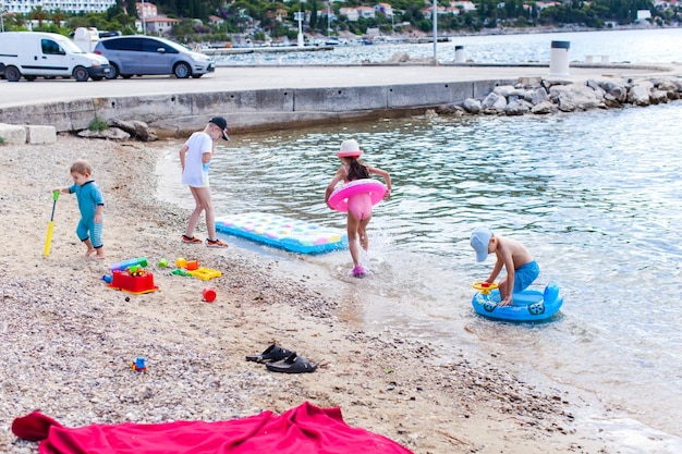 Geschwisterjunge baut im Sommer eine Sandburg am Strand