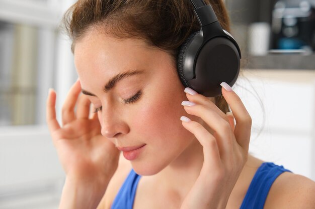 Gesicht einer schönen Frau mit drahtlosen Kopfhörern genießt den Ton hört Musik in drahtlosen Kopfhörern