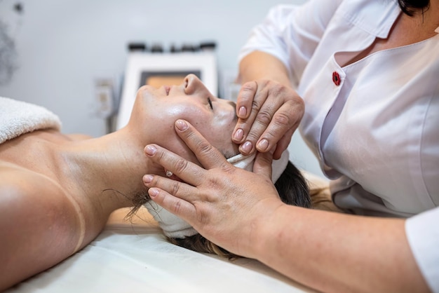 Gesicht einer zufriedenen Kundin einer Frau, die im Salon liegt und von einer entspannenden Prozedur high wird