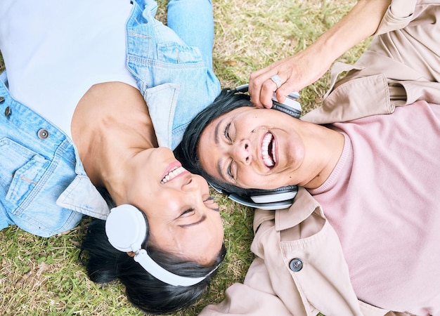 Gesicht Freunden und glücklich mit Frauen und Kopfhörern Musik hören im Freien mit Podcast und Technologie Glück Draufsicht Radio und Audio-Streaming im Park mit Menschen zusammen und Wellness