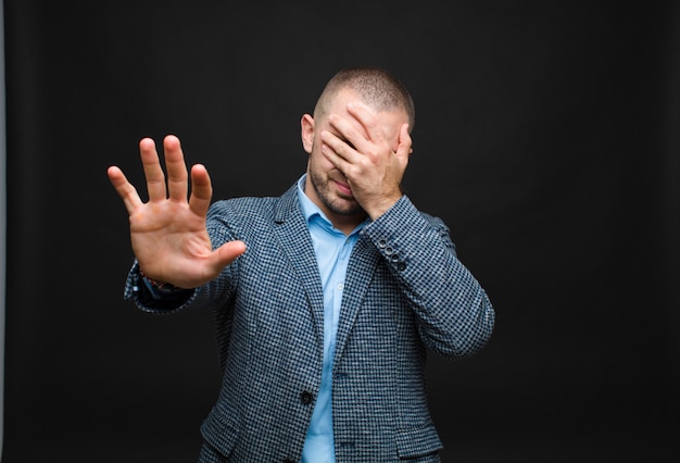 Gesicht mit der Hand bedecken und andere Hand nach vorne legen, um anzuhalten, Fotos oder Bilder ablehnen