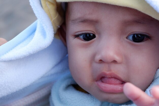 Gesichtsausdruck des Babys, wenn es von seiner Mutter gehalten wird. Sie ist ein süßes Baby.