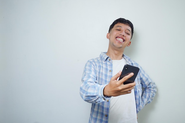 Gesichtsausdruck eines glücklichen asiatischen Mannes, der einen Videoanruf macht, der auf weißem Hintergrund isoliert ist