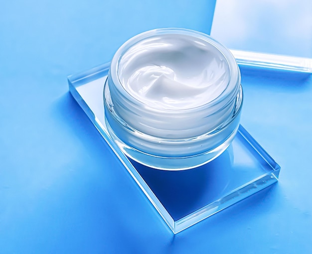 Gesichtscreme-feuchtigkeitscreme-glas auf glas und blauem hintergrund schönheitsprodukt und hautpflege-kosmetikwissenschaft