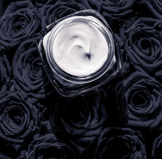 Gesichtscreme-Hautfeuchtigkeitscreme und schwarze Rosen blüht Luxus-Hautpflege-Kosmetikprodukt auf floralem Hintergrund als Beauty-Markenurlaubs-Flatlay-Design