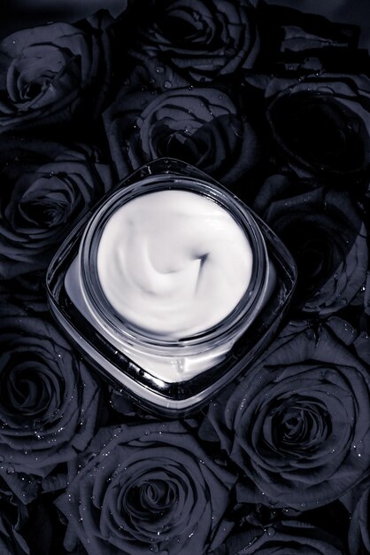 Gesichtscreme-Hautfeuchtigkeitscreme und schwarze Rosen blüht Luxus-Hautpflege-Kosmetikprodukt auf floralem Hintergrund als Beauty-Markenurlaubs-Flatlay-Design