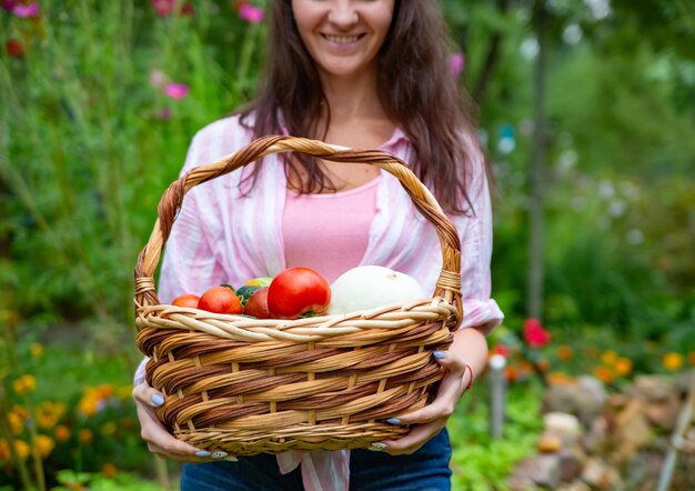 Gesichtslos glückliche lächelnde Frau Bauern halten einen Korb mit Gemüse aus ihrem Garten