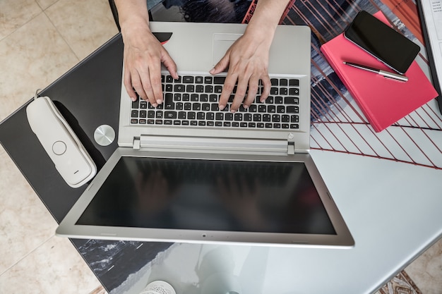 Gesichtsloser Freiberufler mit Laptop bei der Arbeit zu Hause