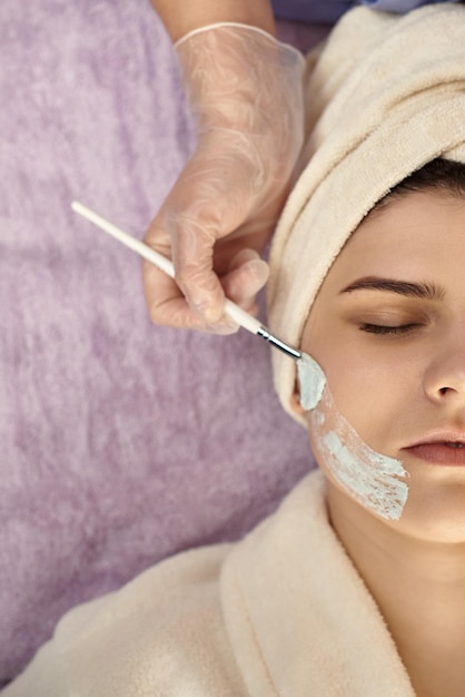 Gesichtspeeling-Maske Spa-Schönheitsbehandlung Hautpflege Frau bekommt Gesichtspflege von Kosmetikerin im Spa-Salon