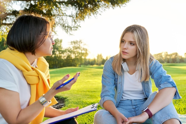 Gespräch einer jungen Frau mit einem Psychologen-Sozialarbeiter im Freien bei einem Treffen im Park auf dem Rasen Professionelle Unterstützung Unterstützung des Psychologen-Psychiater-Therapeuten