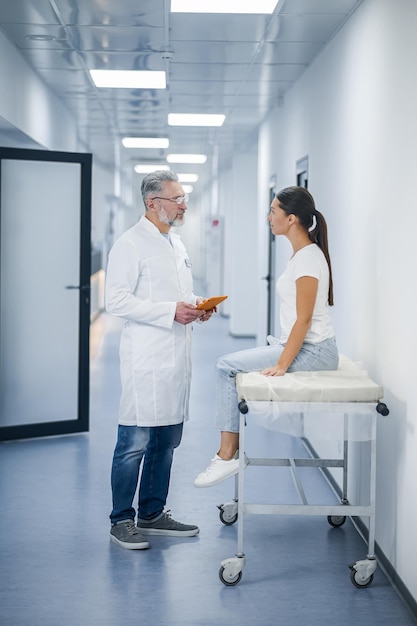 Gespräch mit einem Patienten Grauhaariger Arzt im Gespräch mit dem Patienten vor der MRT