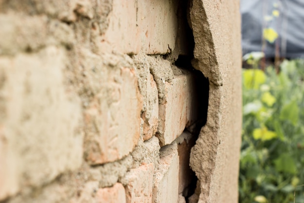 Gesso não tecnológico. Construção de parede de fachada de gesso rachado com tijolo.