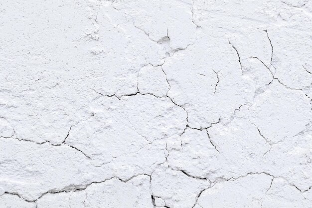 Gesso velho áspero em uma parede de tijolos Fundo abstrato cinza branco