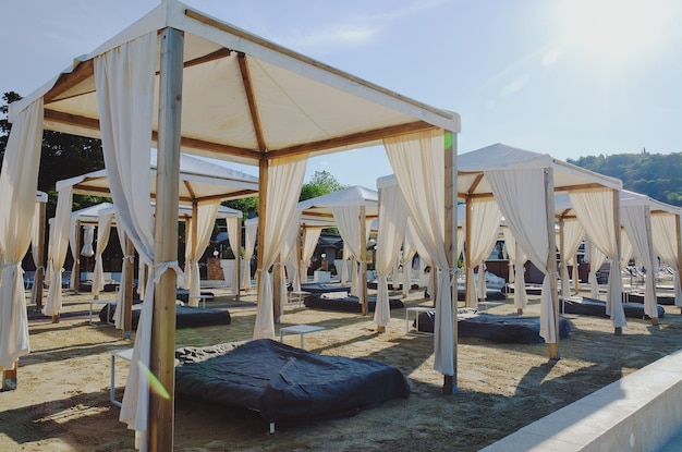 Gestalten Sie das Cabana-Bett im Freien am Sandstrand an sonnigen Tagen landschaftlich. Adriatische Küste und Meer in Slowenien.