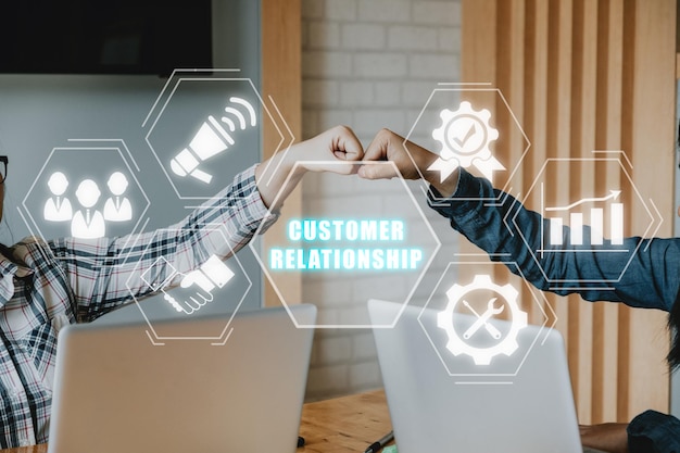 Gestión de relaciones con el cliente Concepto de tecnología de Internet de negocios Jóvenes empresarios unen sus manos con el icono de Gestión de Relaciones con el Cliente en VR creen