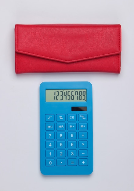 Gestionar el presupuesto familiar. Costos de compra. Calculadora azul con billetera de cuero rojo sobre superficie blanca. Vista superior