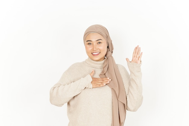 Gesto de juramento, faça um juramento de uma bela mulher asiática usando um hijab isolado no fundo branco