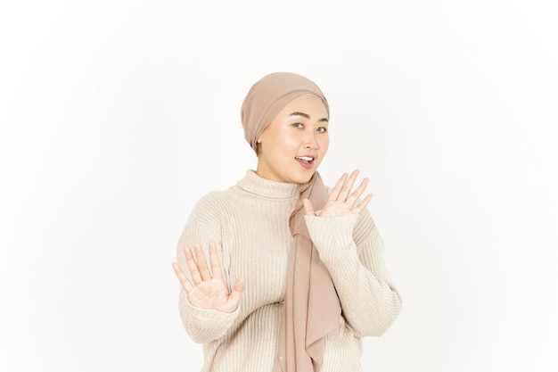 Gesto de parada ou rejeição de uma linda mulher asiática usando um hijab isolado no fundo branco