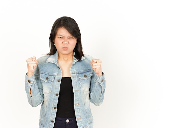 Gesto de raiva de uma bela mulher asiática vestindo jaqueta jeans e camisa preta isolada no branco