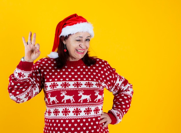 Gesto engraçado de mulher sênior, Natal com chapéu de Papai Noel vermelho