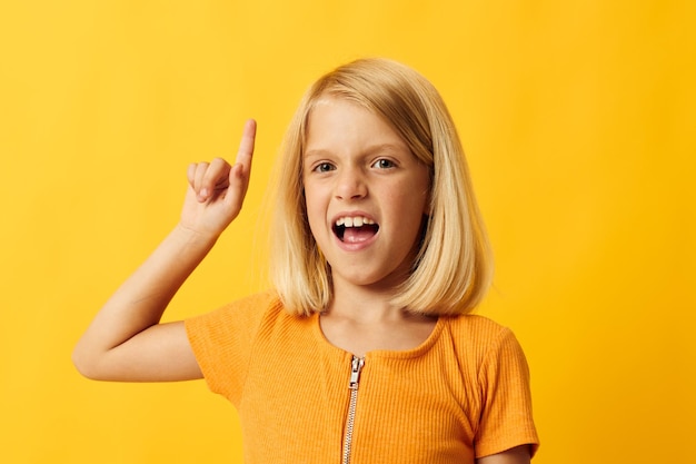 Gesto de mano de niña alegre y fondo amarillo divertido