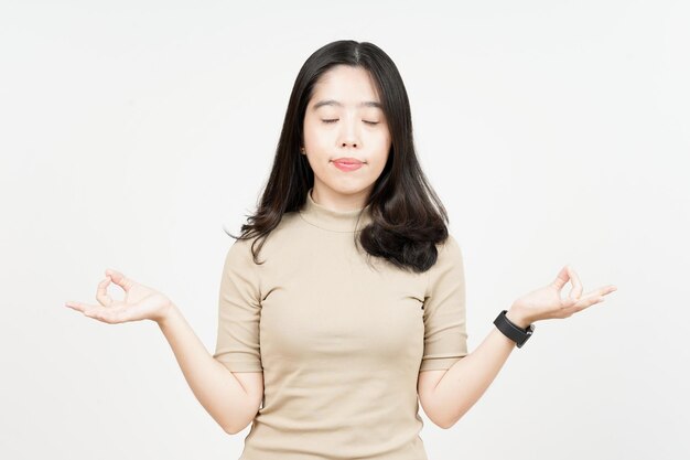 Gesto de meditación de hermosa mujer asiática aislado sobre fondo blanco.