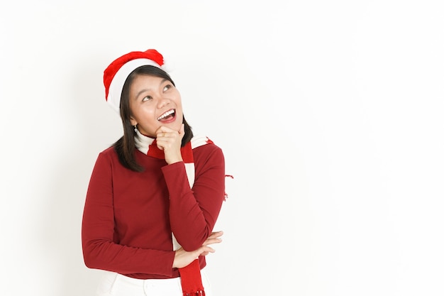 Gesto de pensamiento de hermosa mujer asiática con cuello alto rojo y gorro de Papá Noel aislado en blanco