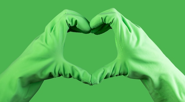 Gesto de signo en forma de corazón con la mano en guantes verdes de servicio de limpieza más limpio con concepto de amor