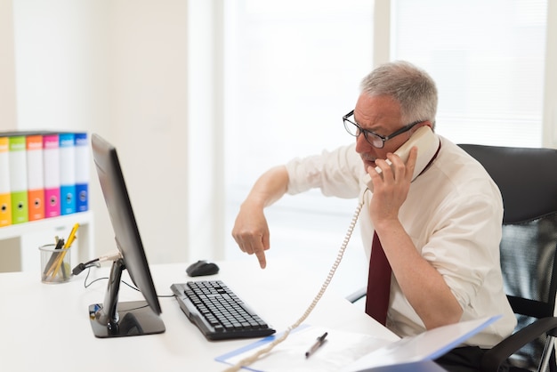 Gestörter Geschäftsmann, der eine Diskussion bei der Unterhaltung am Telefon hat