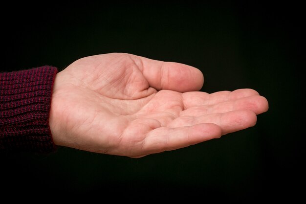 Foto gestreckte männliche hand auf schwarzem isoliertem hintergrund