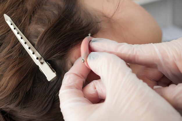 Gestrecktes Lobe-Piercing-Grunge-Konzept Durchbohrtes Frauenohr mit schwarzem Plug-Tunnel Industrie und Turm