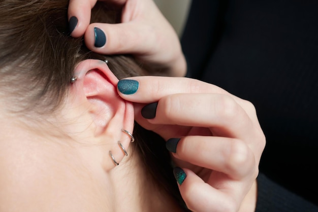 Gestrecktes Lobe-Piercing-Grunge-Konzept Durchbohrtes Frauenohr mit schwarzem Plug-Tunnel Industrie und Turm