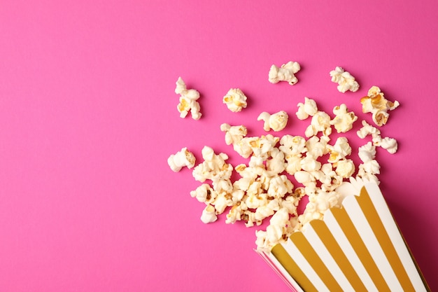 gestreifte Box und Popcorn auf farbigem Hintergrund