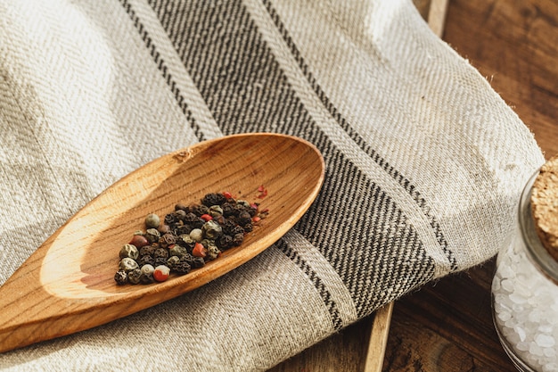 Gestreifte Leinenserviette auf Holztisch mit Küchenutensilien schließen
