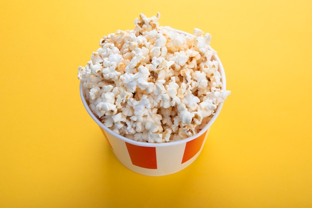 Gestreifte Pappbecher mit Popcorn. Snack für einen Film.