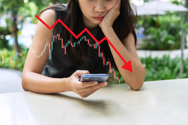 Foto gestresste asiatische geschäftsfrau crypto trader broker investor blick auf das handy, das den krypto-handel an der börse analysiert. abnehmende diagrammdaten fallen herunter. börsenkonzept kopieren sie platz