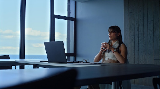 Gestresste Frau, die allein im Büro überarbeitet Müder Manager, der einen mageren Laptop sucht