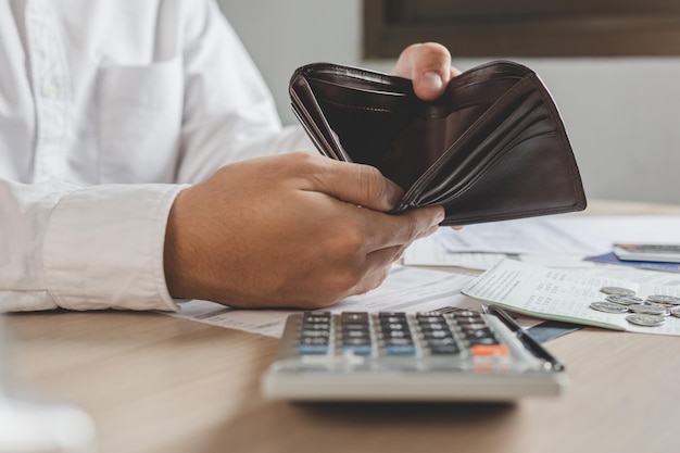 Foto gestresster, problematischer geschäftsmann, mann, der eine leere brieftasche hält und öffnet, kein geld, keine kreditkarte, keine rechnung, kein darlehen oder keine ausgaben zu bezahlen. konkurs-, konkurs- und schuldenfinanzkonzept.