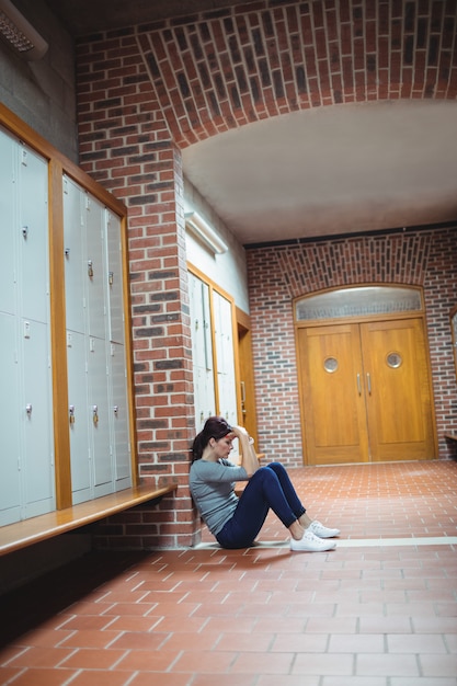 Gestresster reifer Student, der im Umkleideraum sitzt