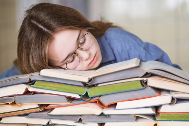 Gestresster Student müde vom harten Lernen mit Büchern in Prüfungsvorbereitung Vorbereitung, überwältigt High-School-Teenager-Mädchen erschöpft von schwierigen Studien oder zu viel Hausaufgaben, Cram-Konzept