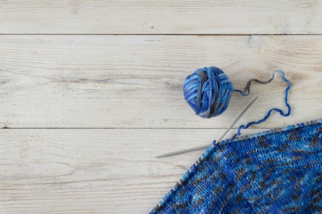 Gestrick auf Stricknadeln ein Ball aus blauem Garn kopieren Raum