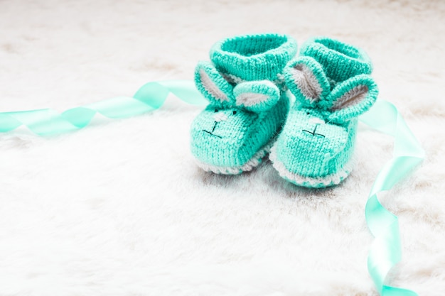 Gestrickte grüne Babyschuhe mit Kaninchenmaulkorb für kleine Jungen