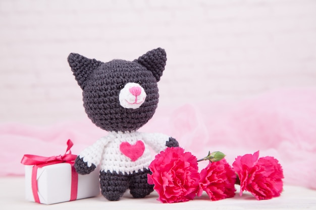 Gestrickte Katze mit Herz. Valentinstag Dekor. Gestricktes Spielzeug, Amigurumi. Valentinstaggrußkarte.