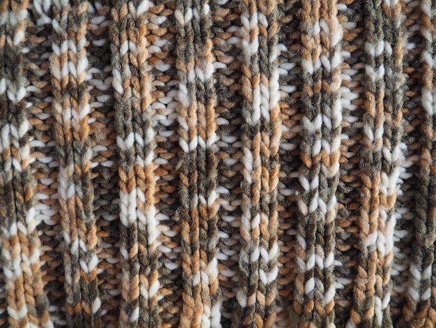 Gestrickte oder gehäkelte Leinwand. Stricken mit Stil – gestrickter Kaugummi. Weiße, graue, braune, beige Fäden. Ein Wellenmuster. Maschinenviskos.