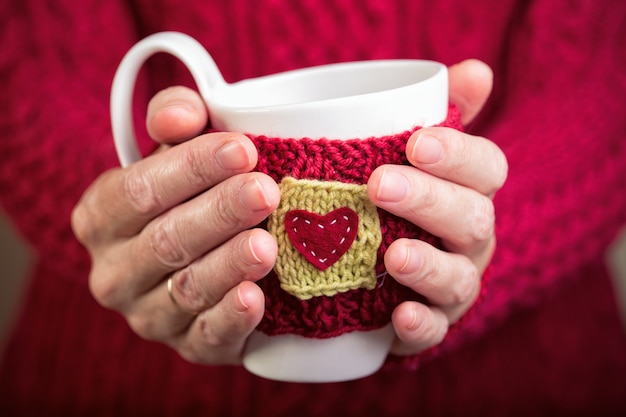 Gestrickte Wollcups in Frauenhänden