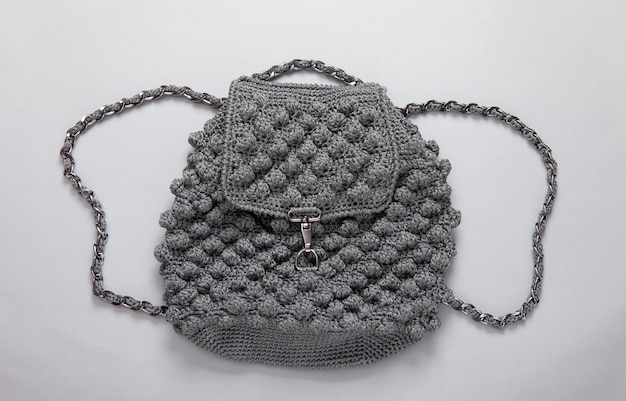 Gestrickter Rucksack auf grauem Hintergrund Draufsicht