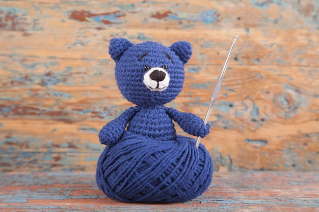 Foto gestricktes kleines betreffen ein altes hölzernes. handgemachtes, gestricktes spielzeug. amigurumi