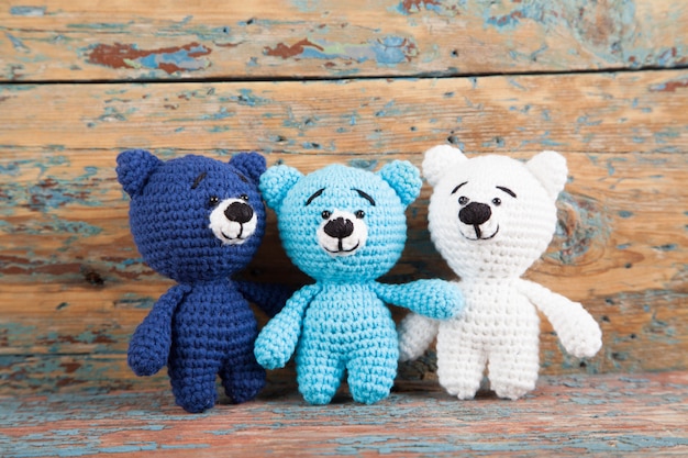 Gestricktes kleines betreffen einen alten hölzernen Hintergrund. Handgemachtes, gestricktes Spielzeug. Amigurumi